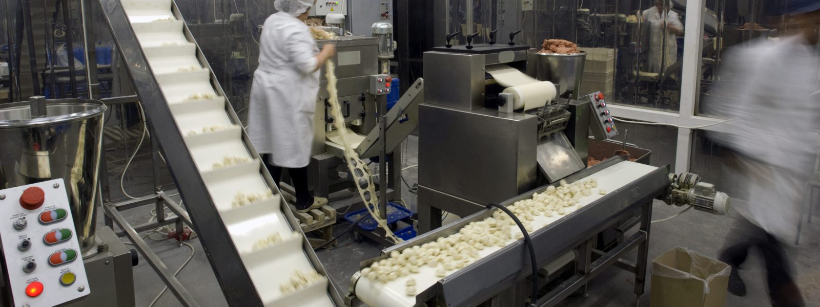 Automated production line in modern food factory. Ravioli production. People working.